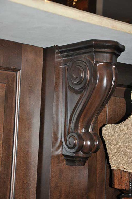 A close up of a wooden corbel on a cabinet