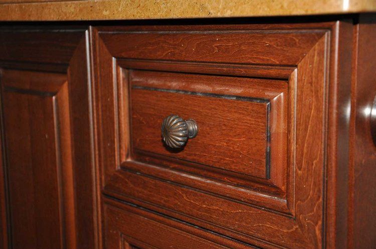 A close up of a wooden cabinet with a drawer and a handle.