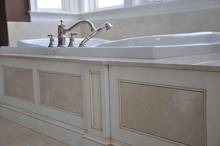 A bathtub with a faucet on top of it in a bathroom.