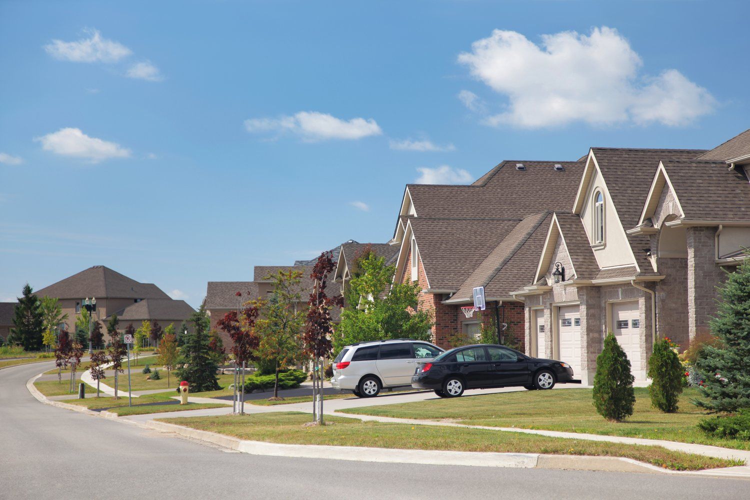 A row of houses with cars parked in front of them