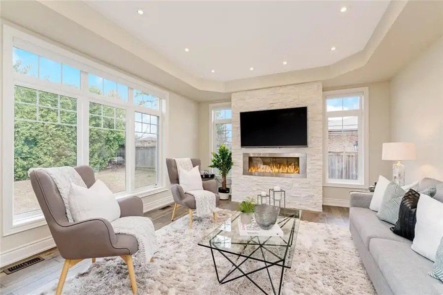 A living room with a couch , chairs , coffee table and television.