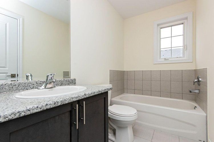 A bathroom with a sink , toilet , tub and mirror.
