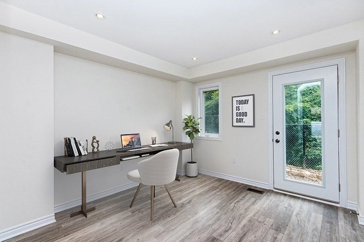 A room with a desk and chair in it and a door.