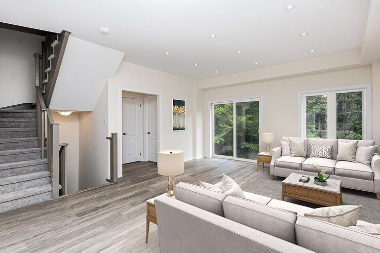 A living room with a couch , coffee table , and stairs.