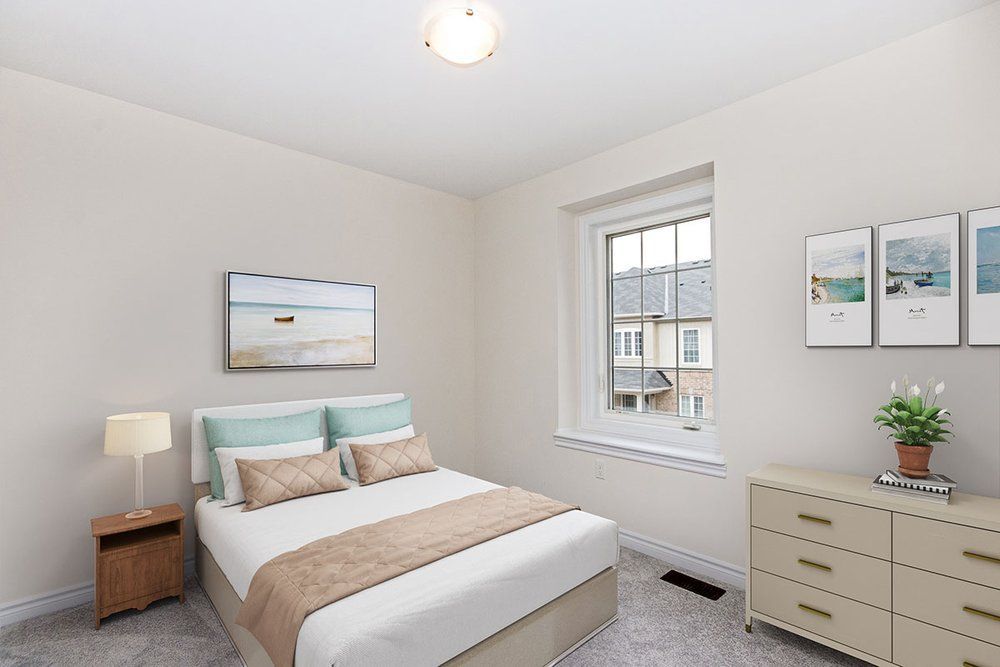 A bedroom with a bed , dresser , nightstand and window.