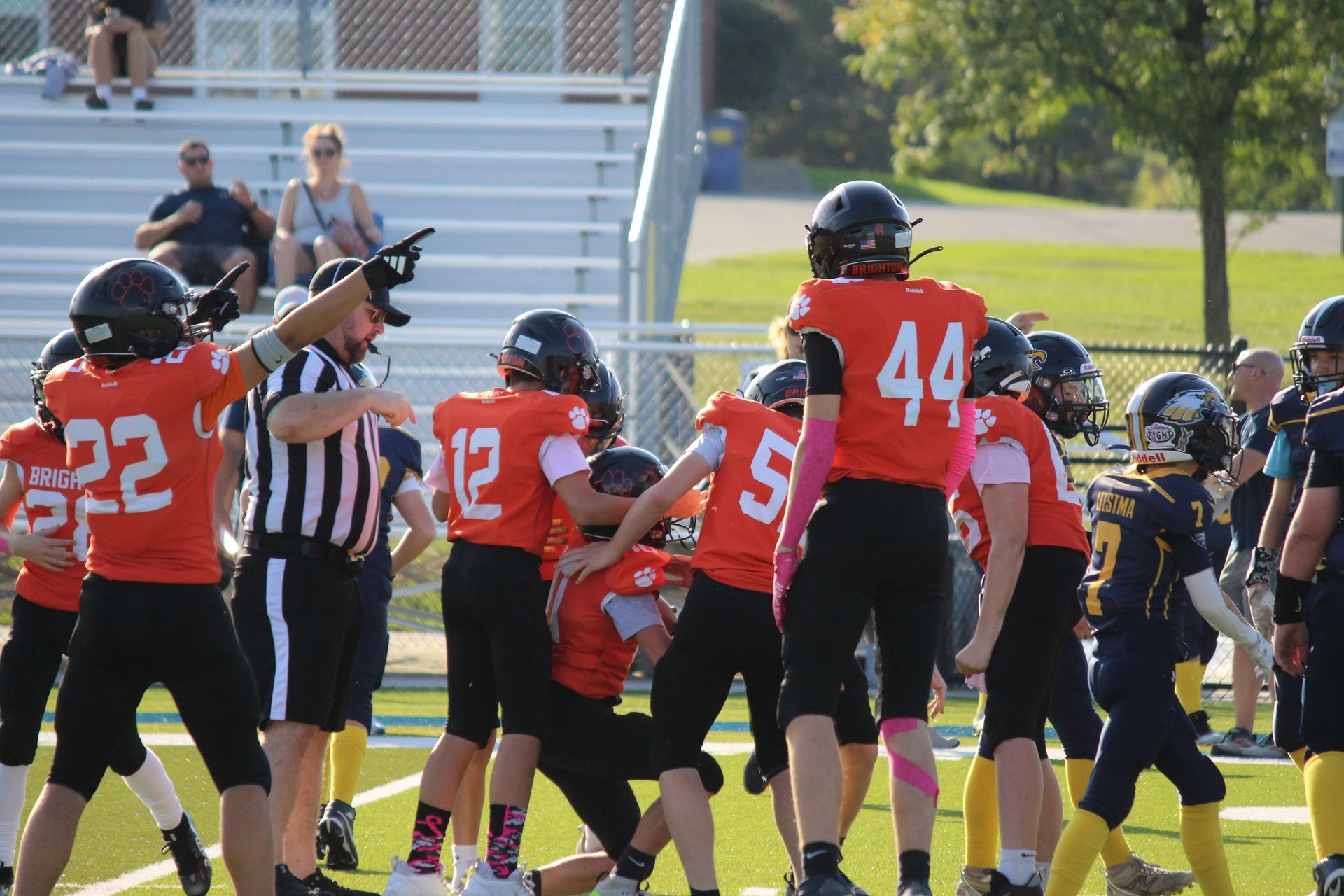 Football players and referees gathered on a field during a game timeout