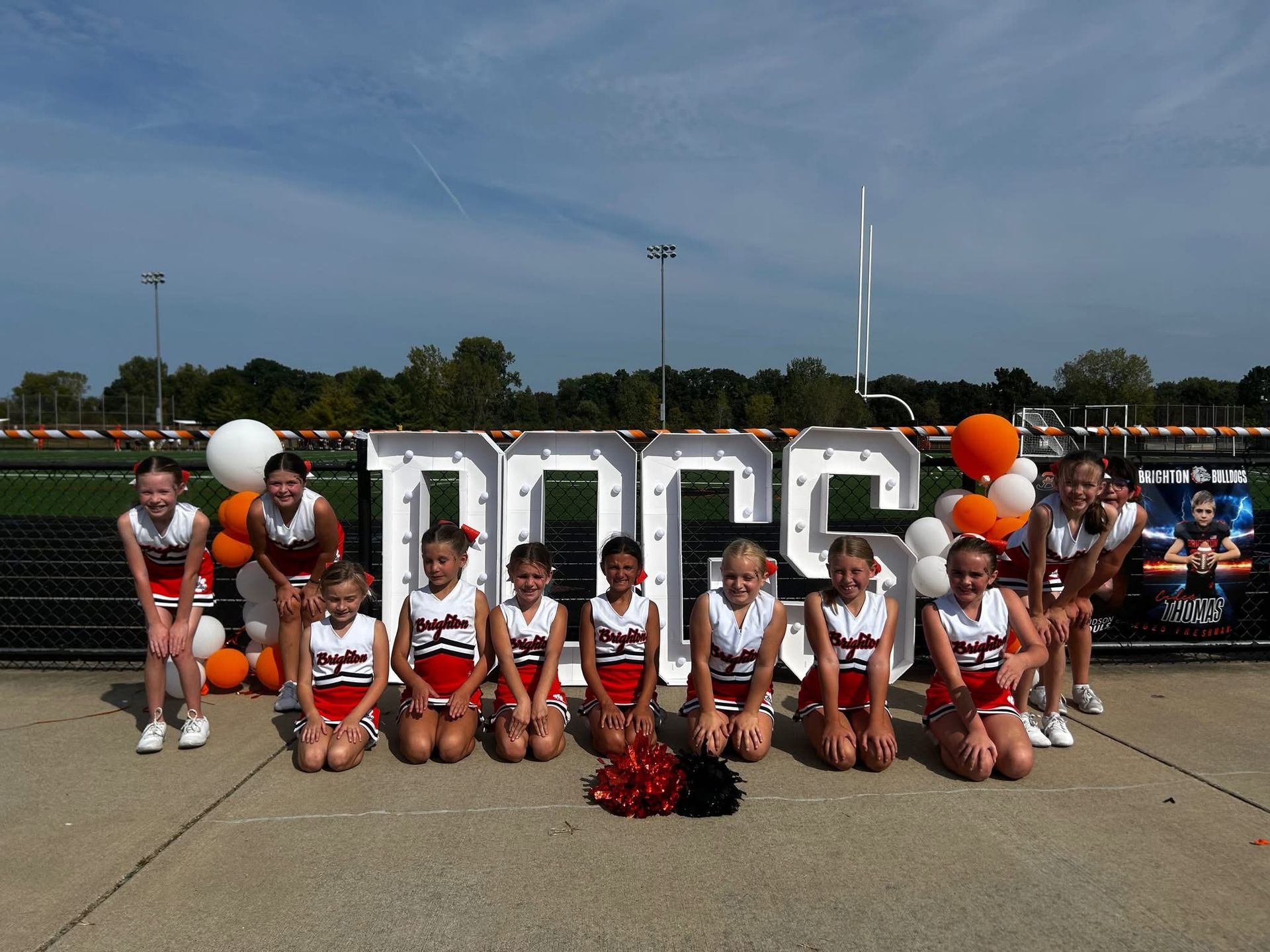 Cheer team posing in front of large 
