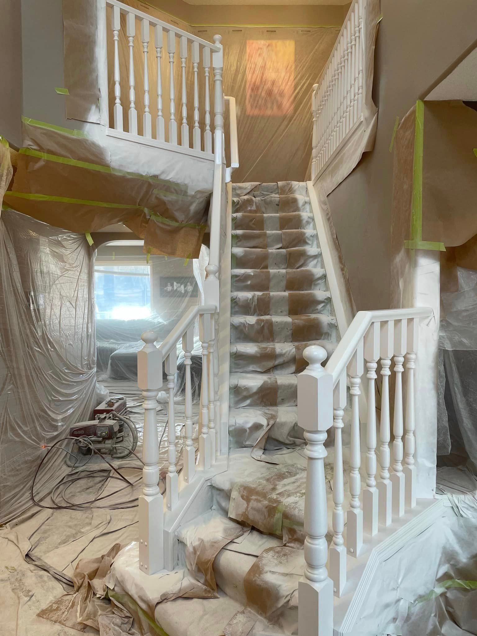 A staircase in a house is being painted white.