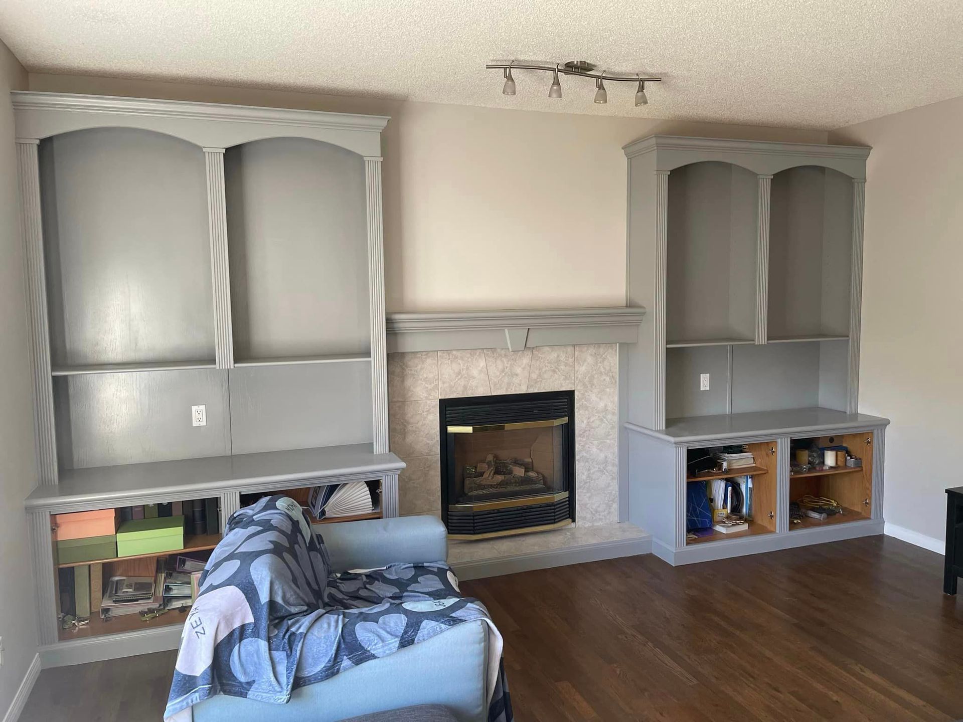 A living room with a fireplace , couch , and shelves.