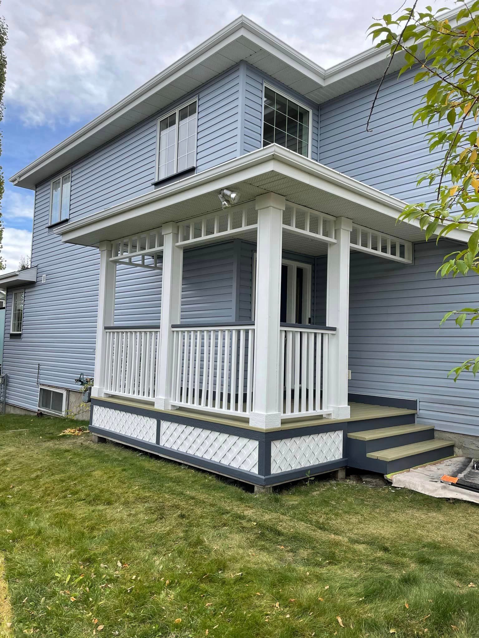 A blue house with a white porch and stairs.