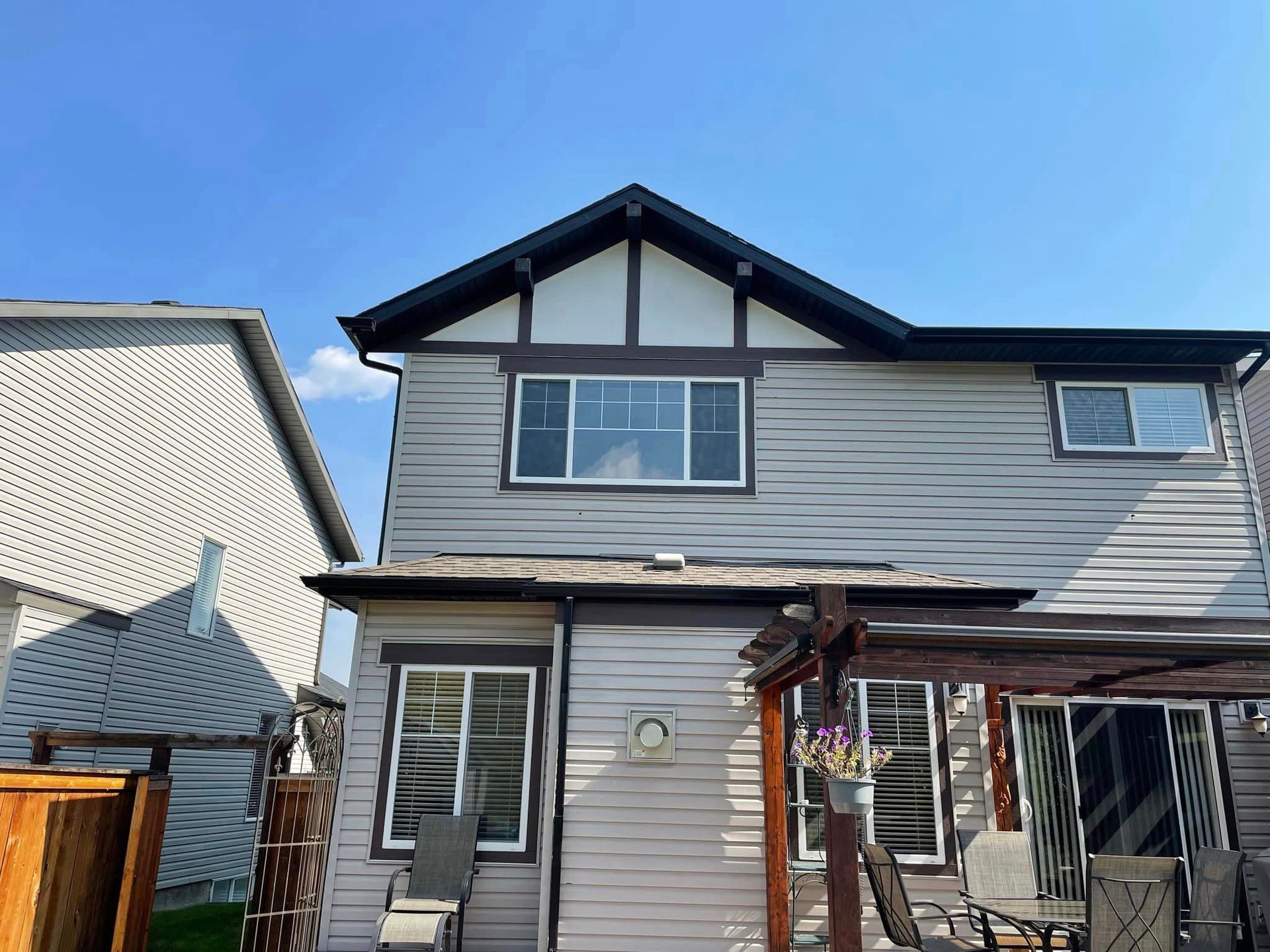 The back of a house with a lot of windows and a pergola.