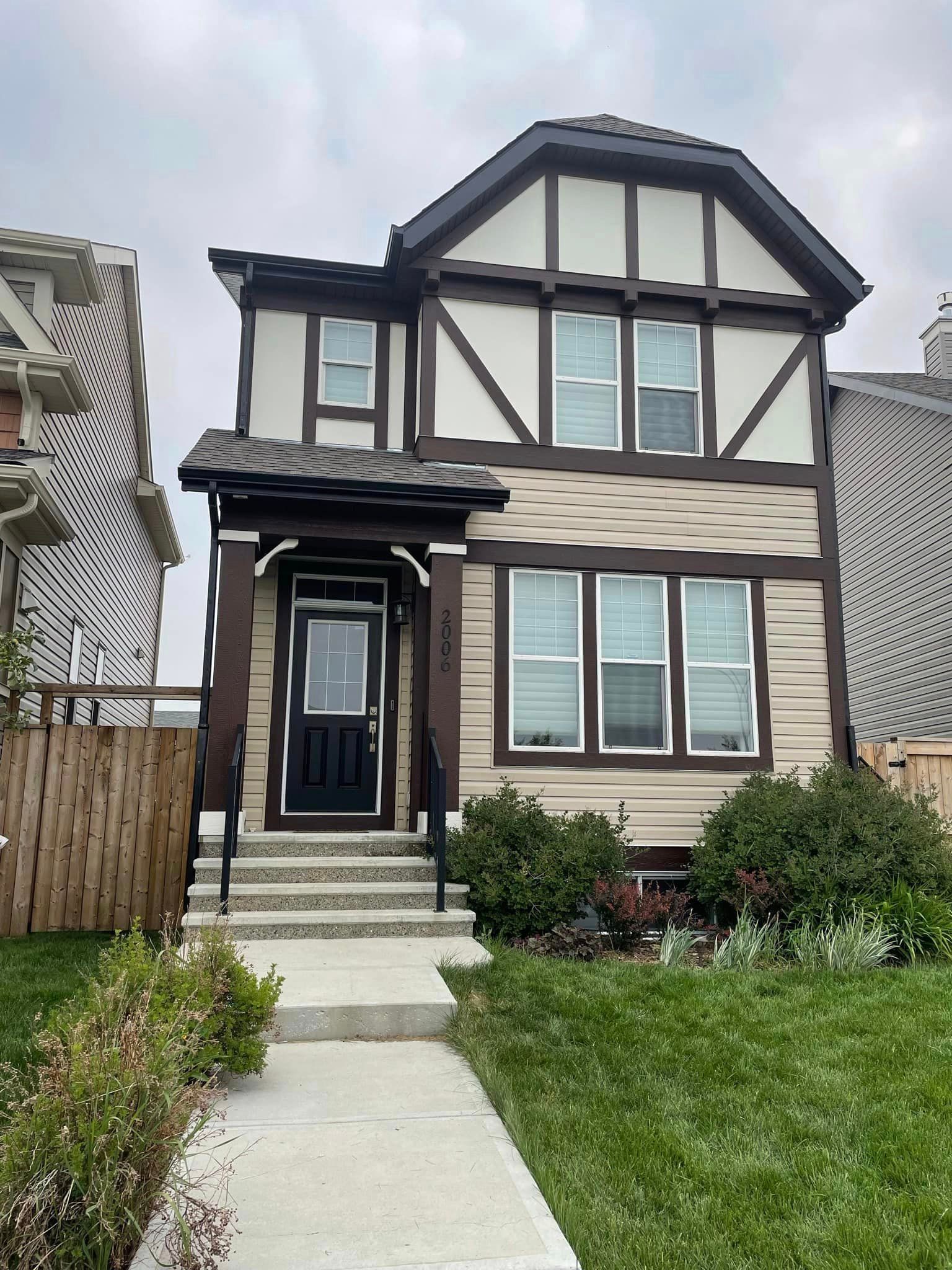 A house with a lot of windows and a fence in front of it.