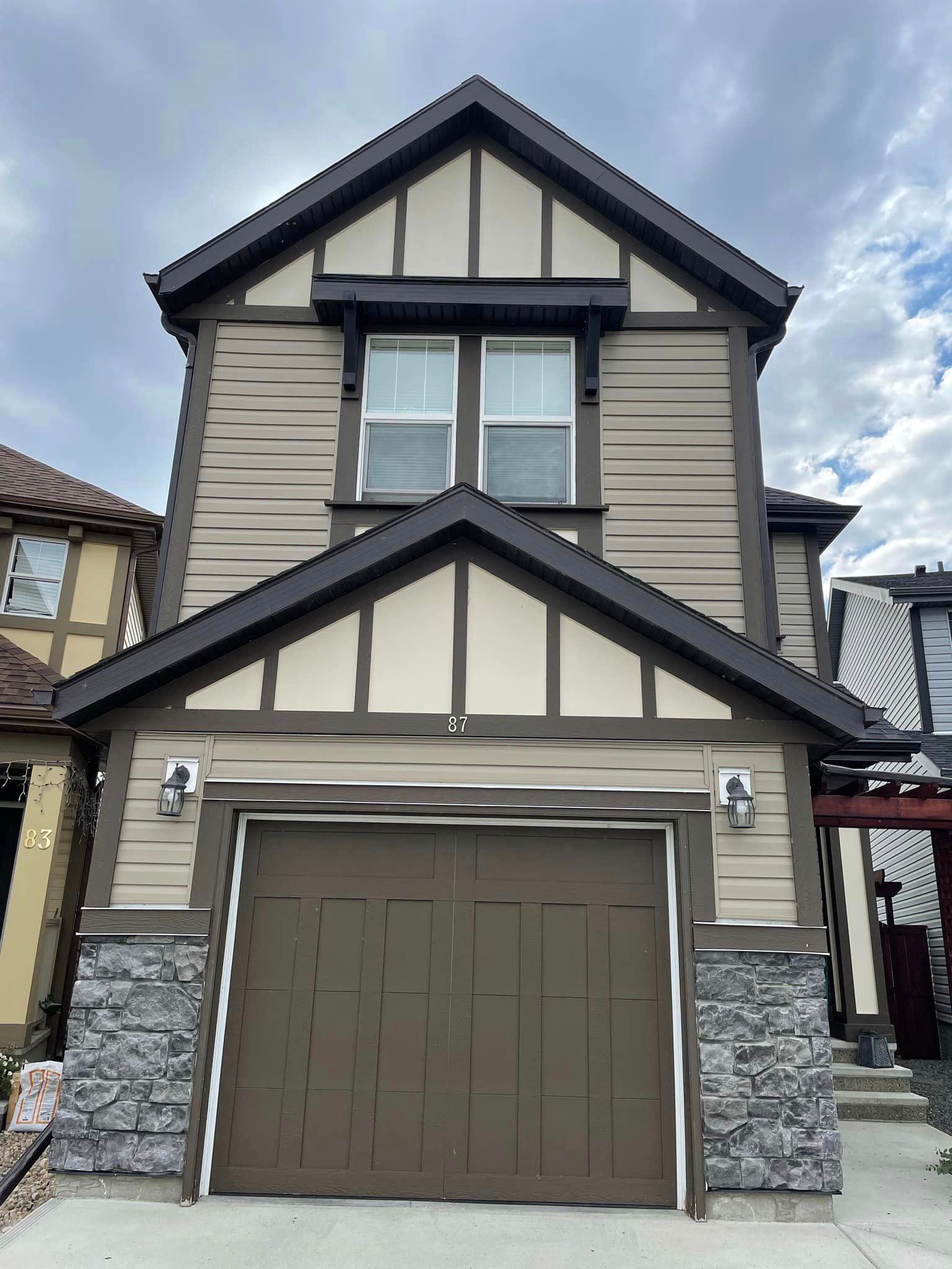 The front of a house with a brown garage door.