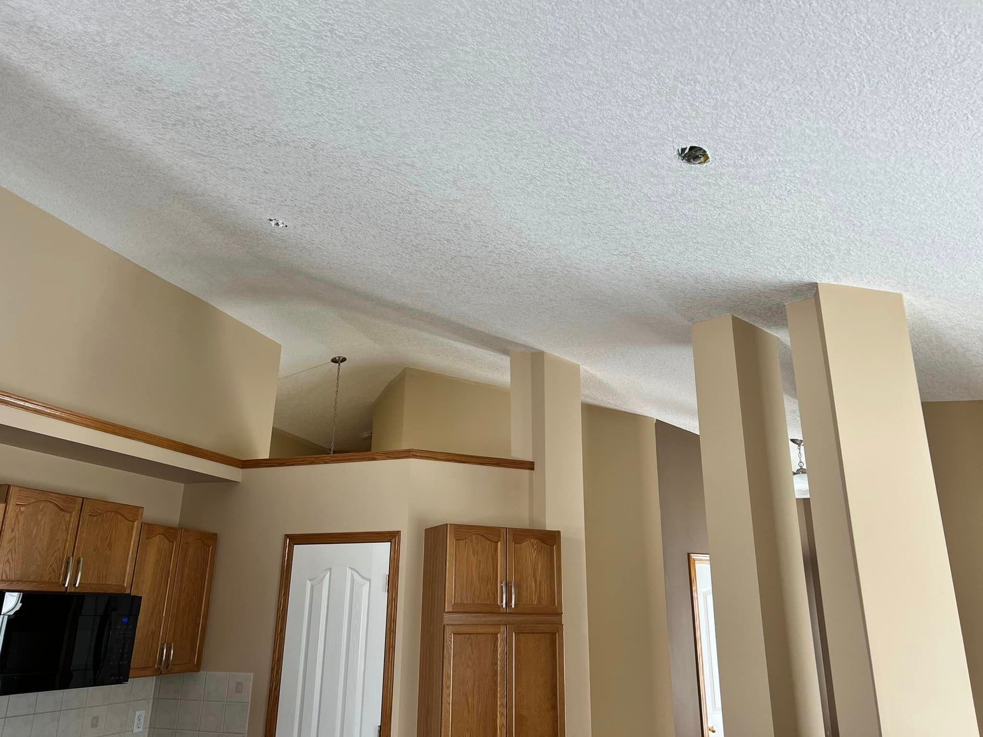 A kitchen with wooden cabinets and a white ceiling.