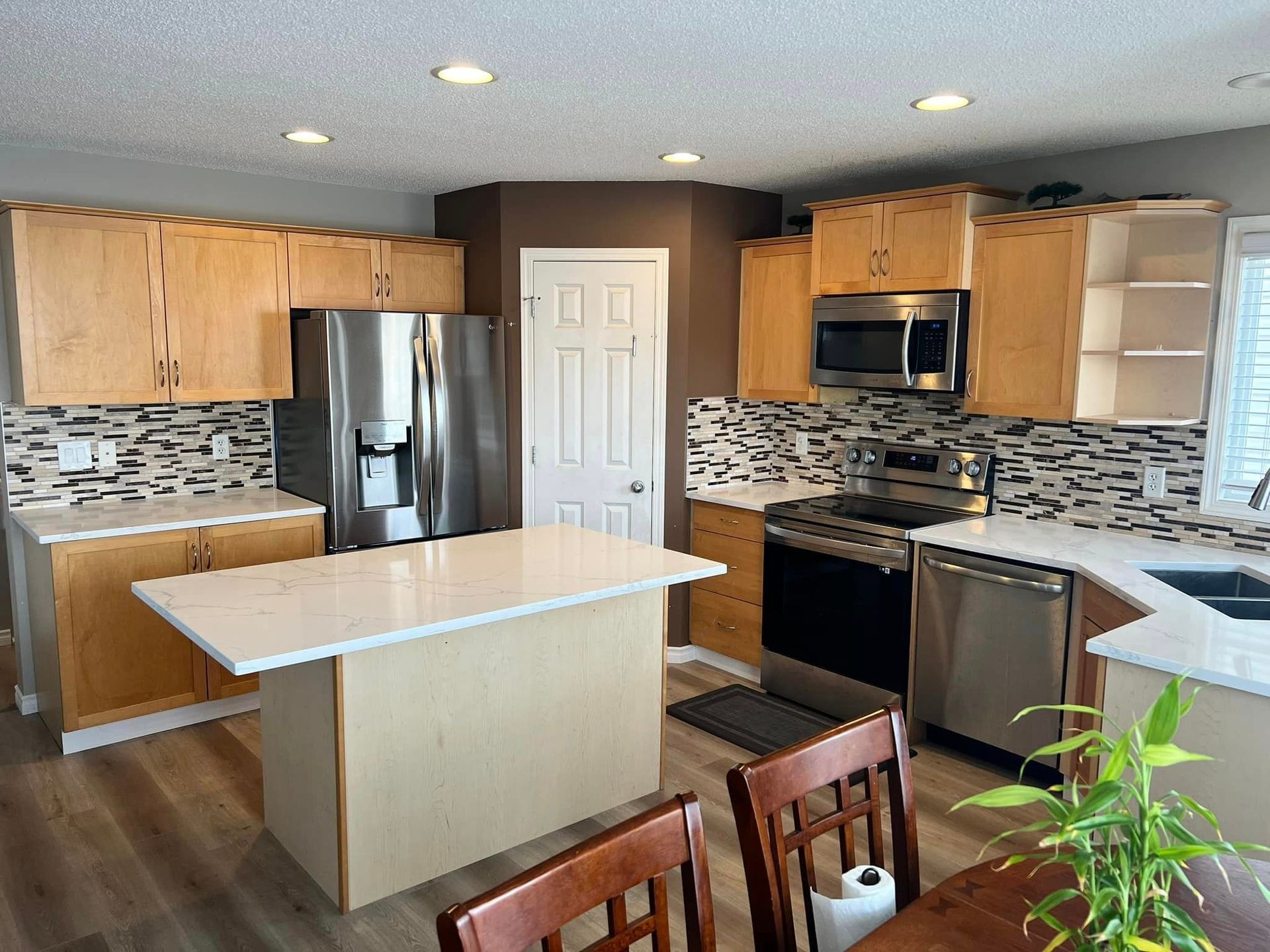 A kitchen with stainless steel appliances and wooden cabinets