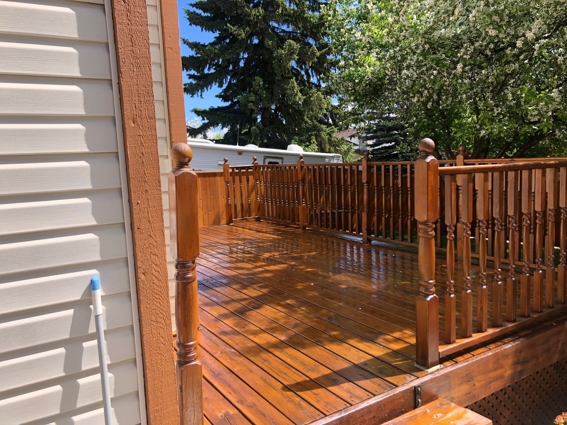 A wooden deck with a railing is sitting next to a house.