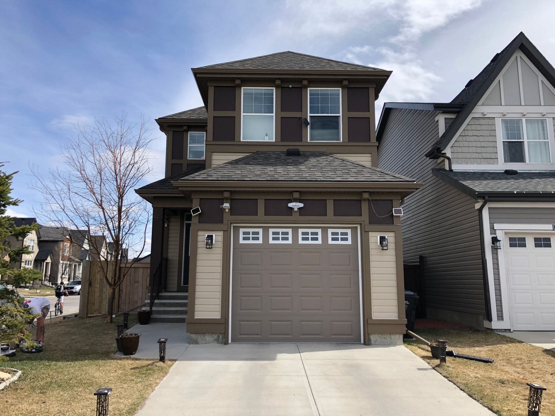 A house with a garage and a driveway in front of it.