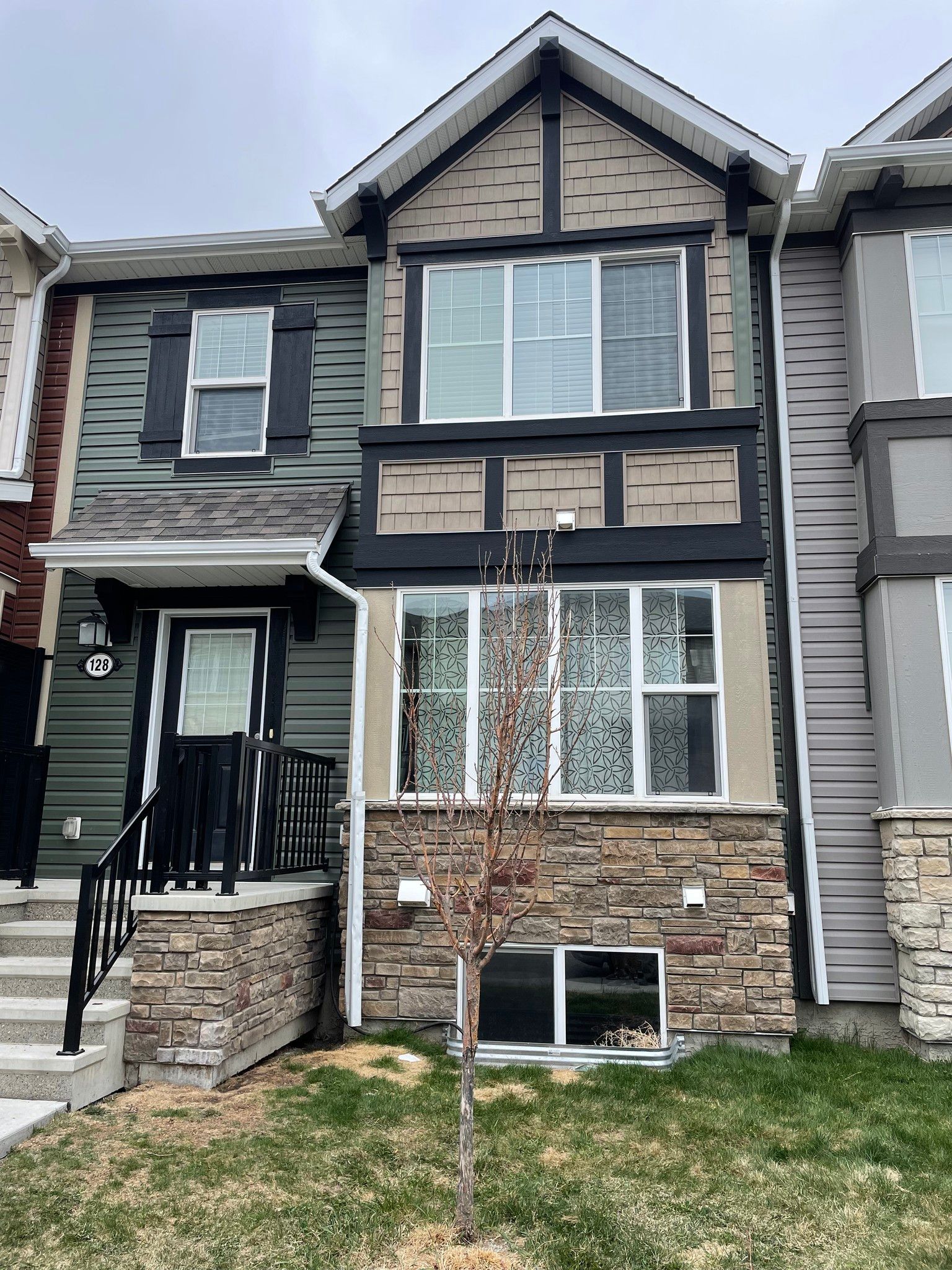 A house with a lot of windows and a tree in front of it.