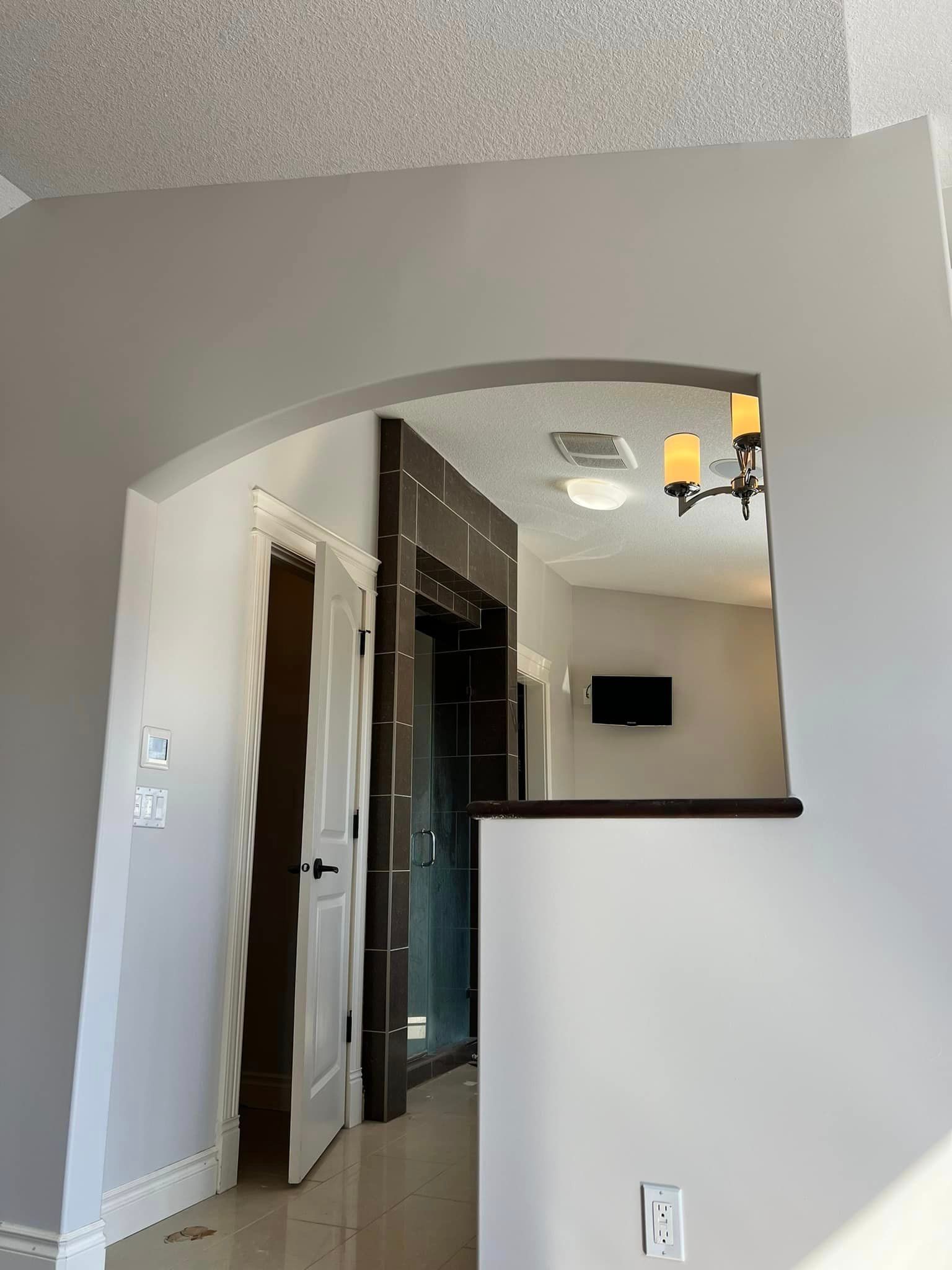 A hallway in a house with a chandelier hanging from the ceiling.
