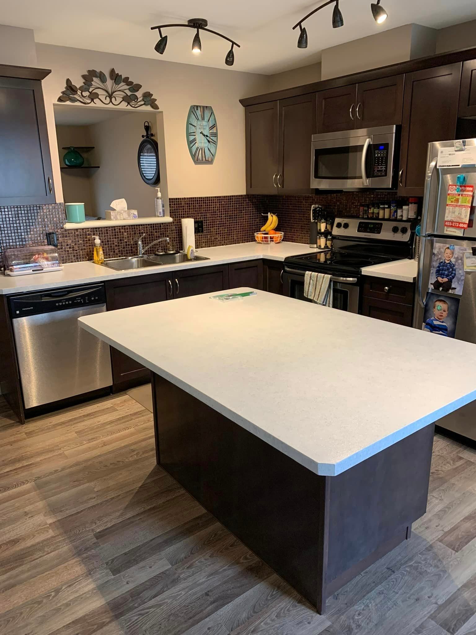 A kitchen with a large island and stainless steel appliances.