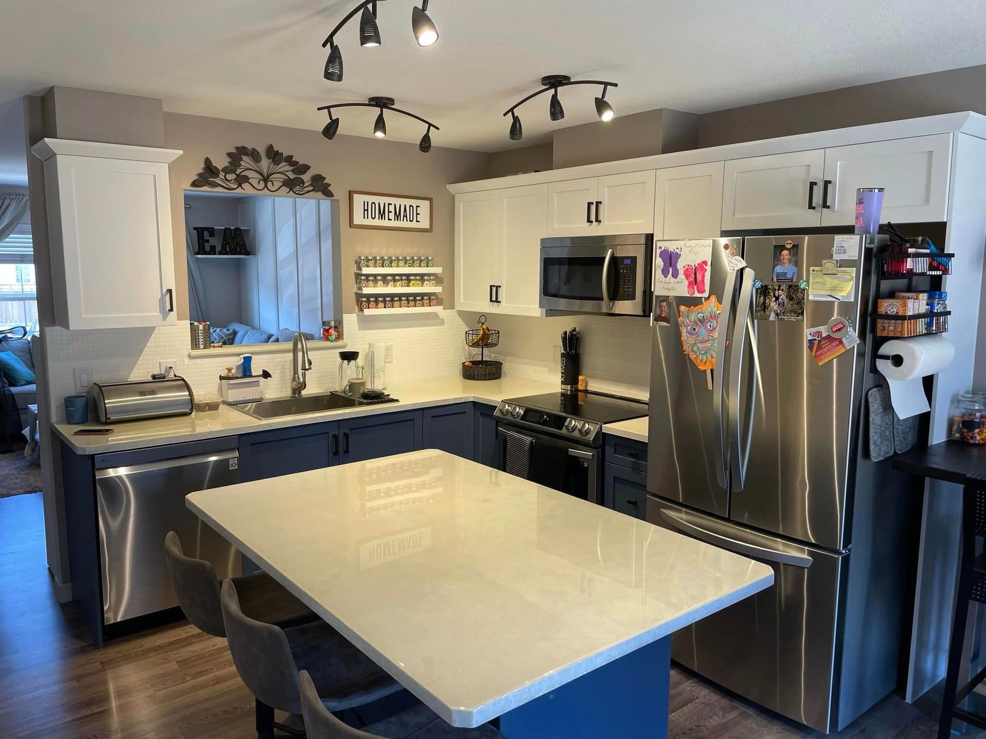 A kitchen with stainless steel appliances and a large island in the middle.