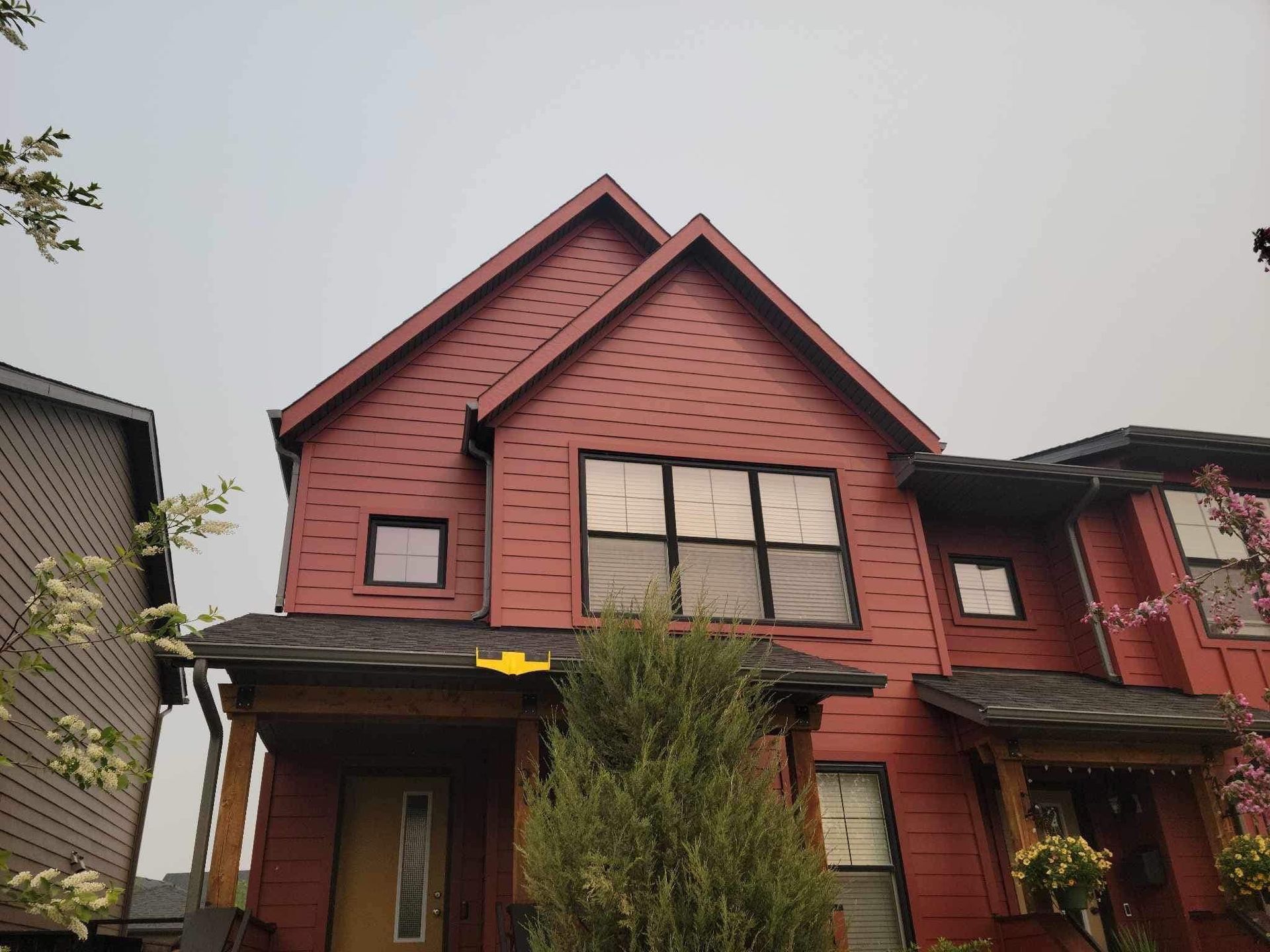 A red house with a roof and a lot of windows