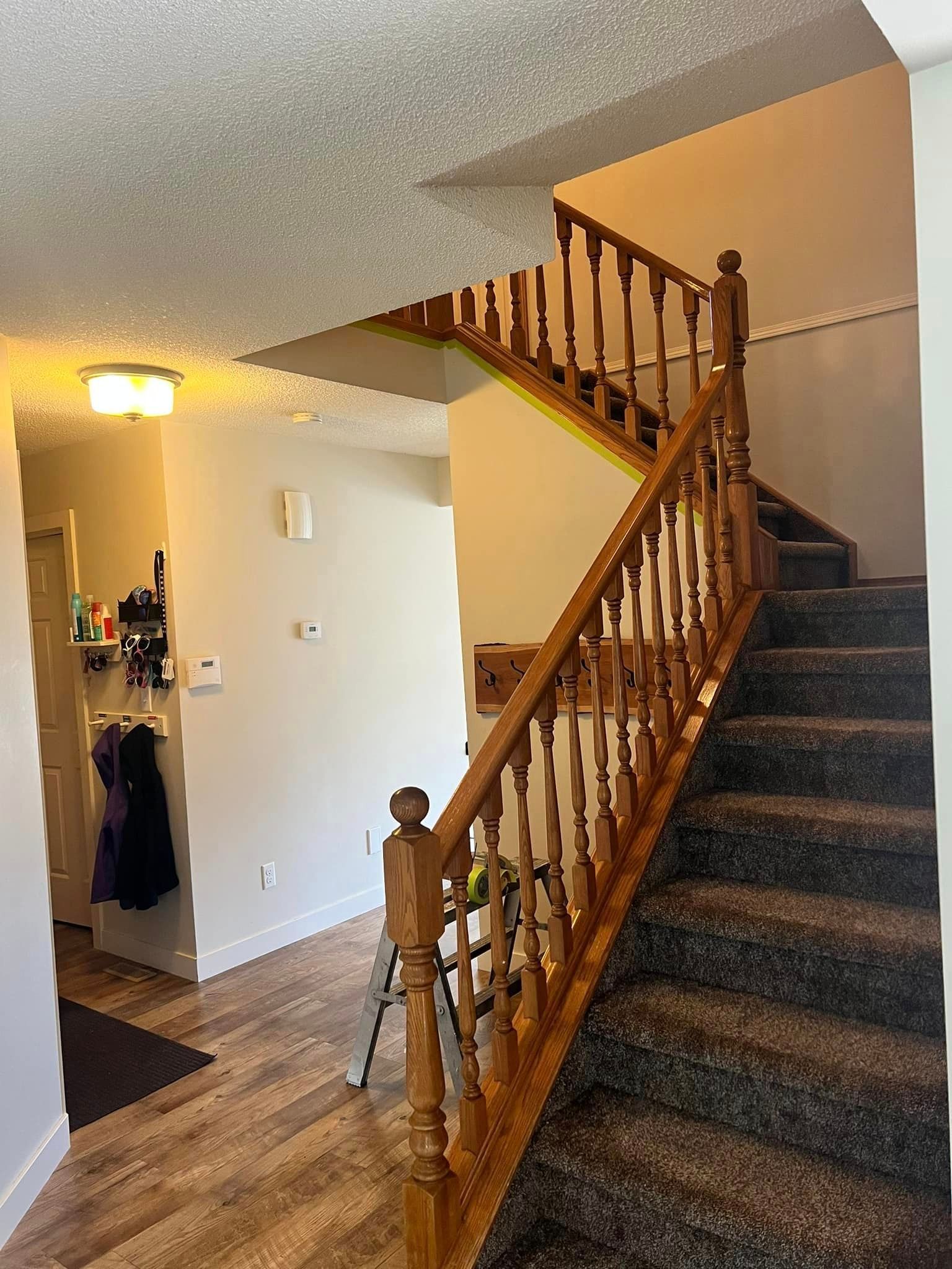 A staircase in a house with a wooden railing and carpeted steps.