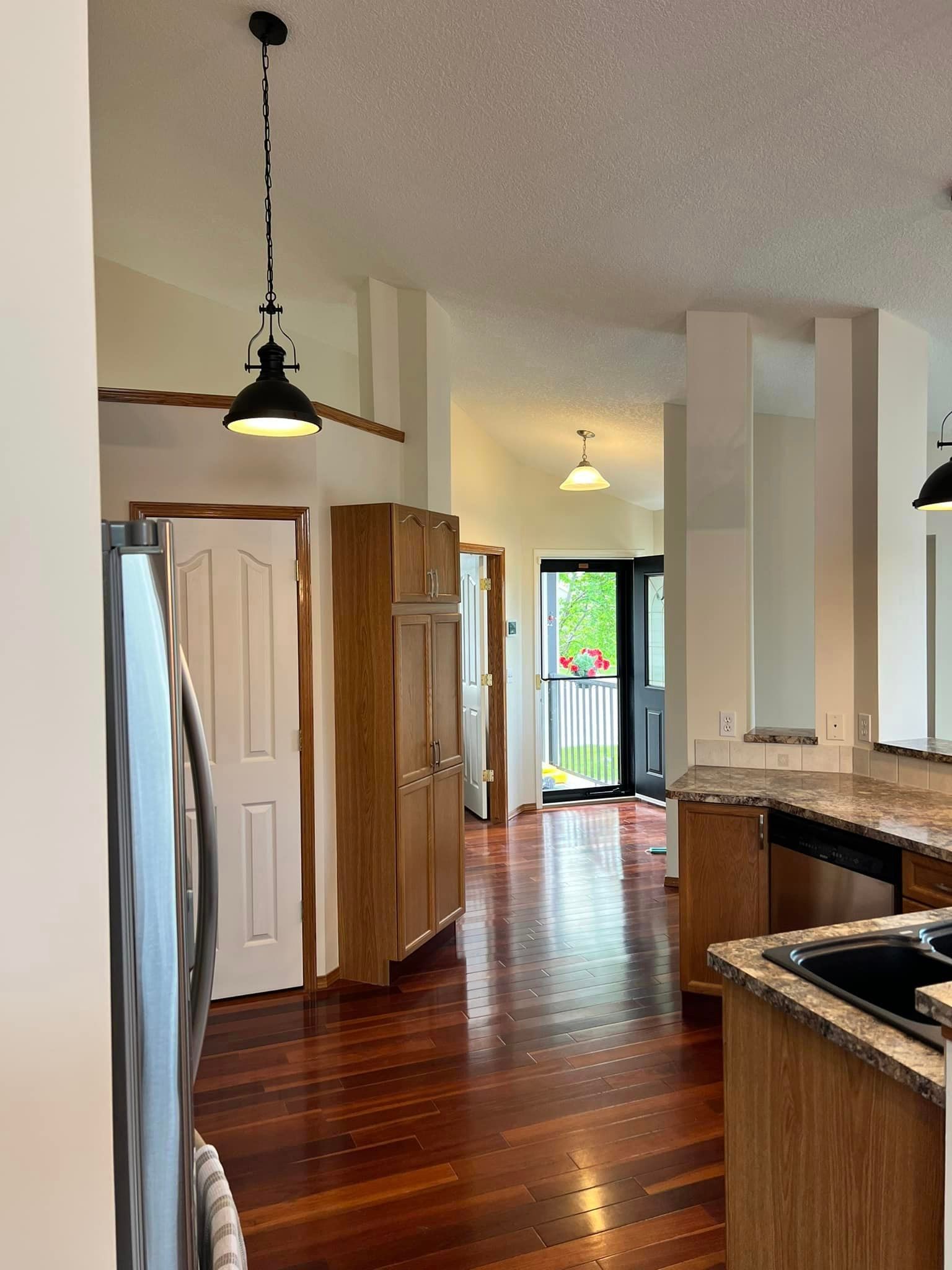 A kitchen with hardwood floors and stainless steel appliances