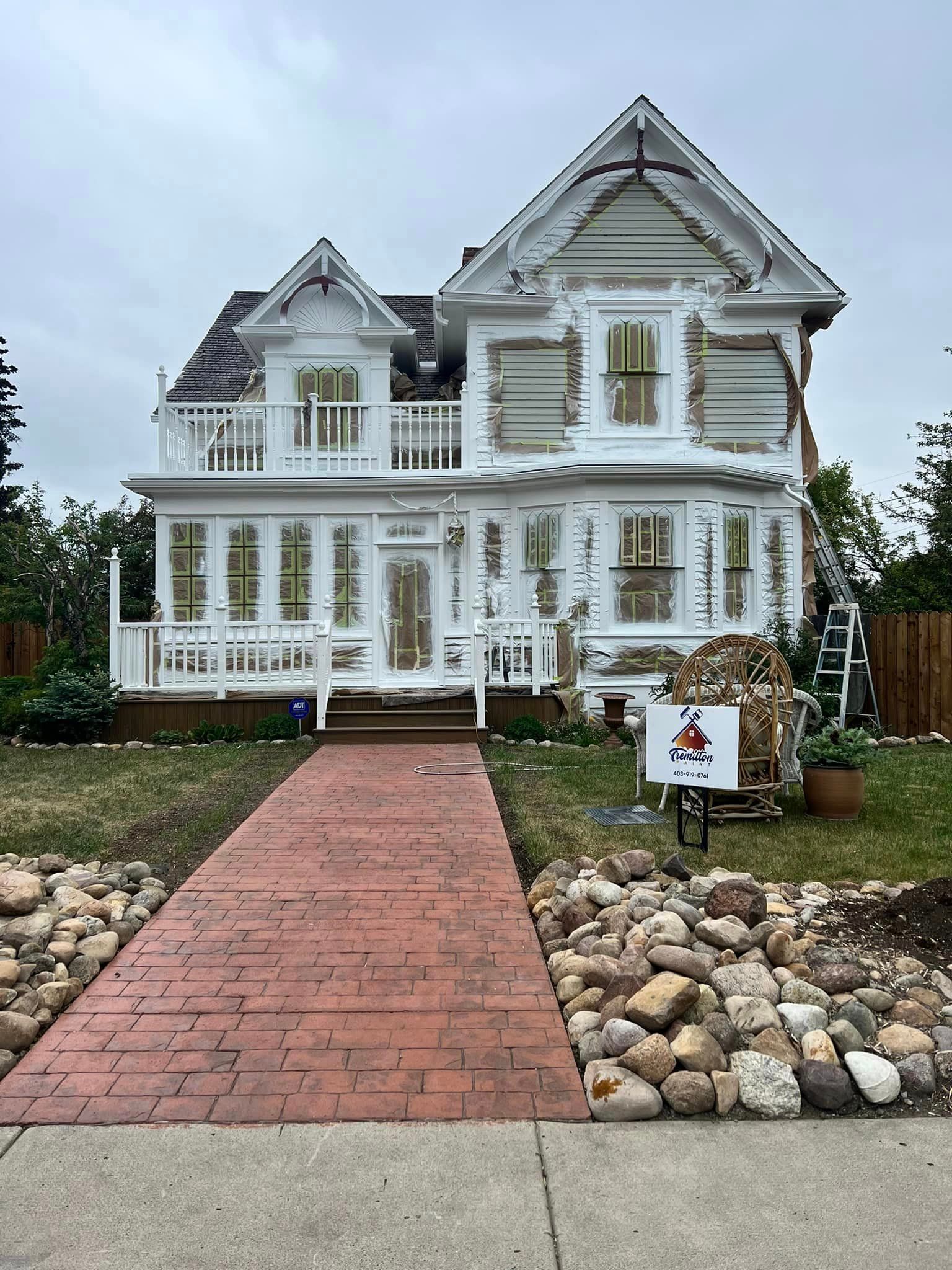 A large white house with a brick walkway leading to it.