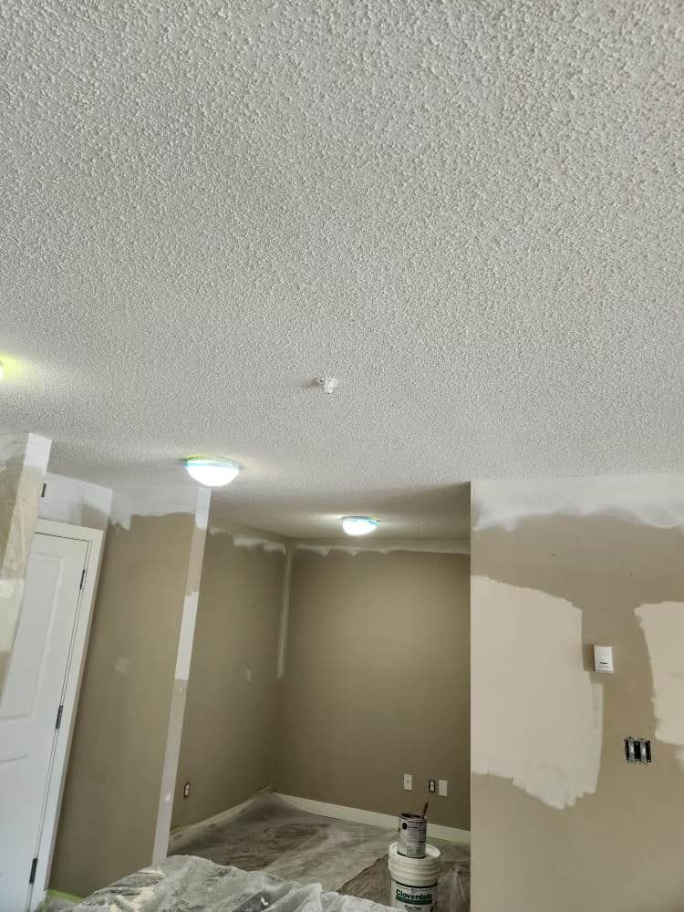 A room with a ceiling that is being painted.