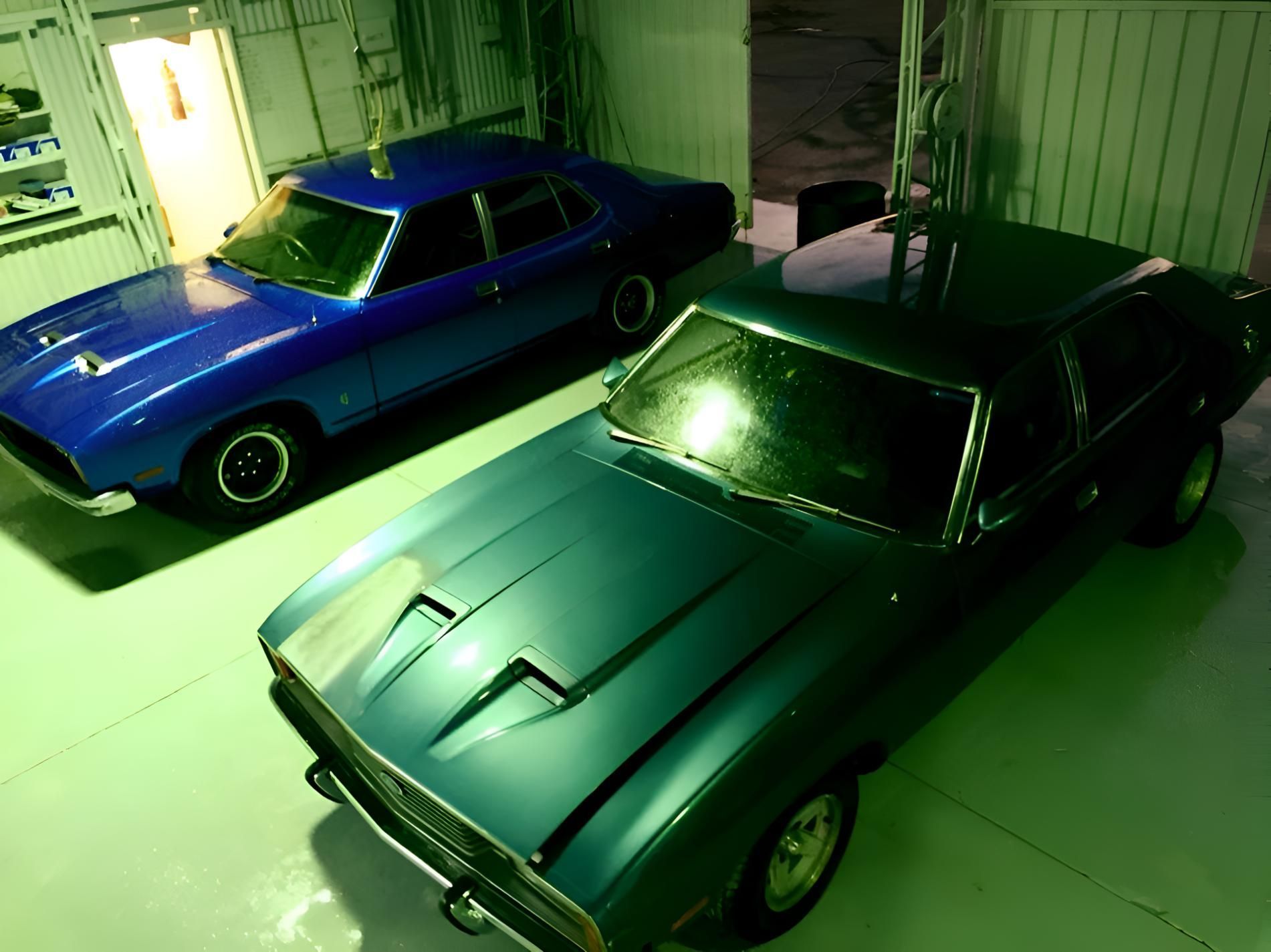 A Blue And a Green Car Are Parked Next To Each Other In A Garage — P & V Panel Works In Alice Springs, NT