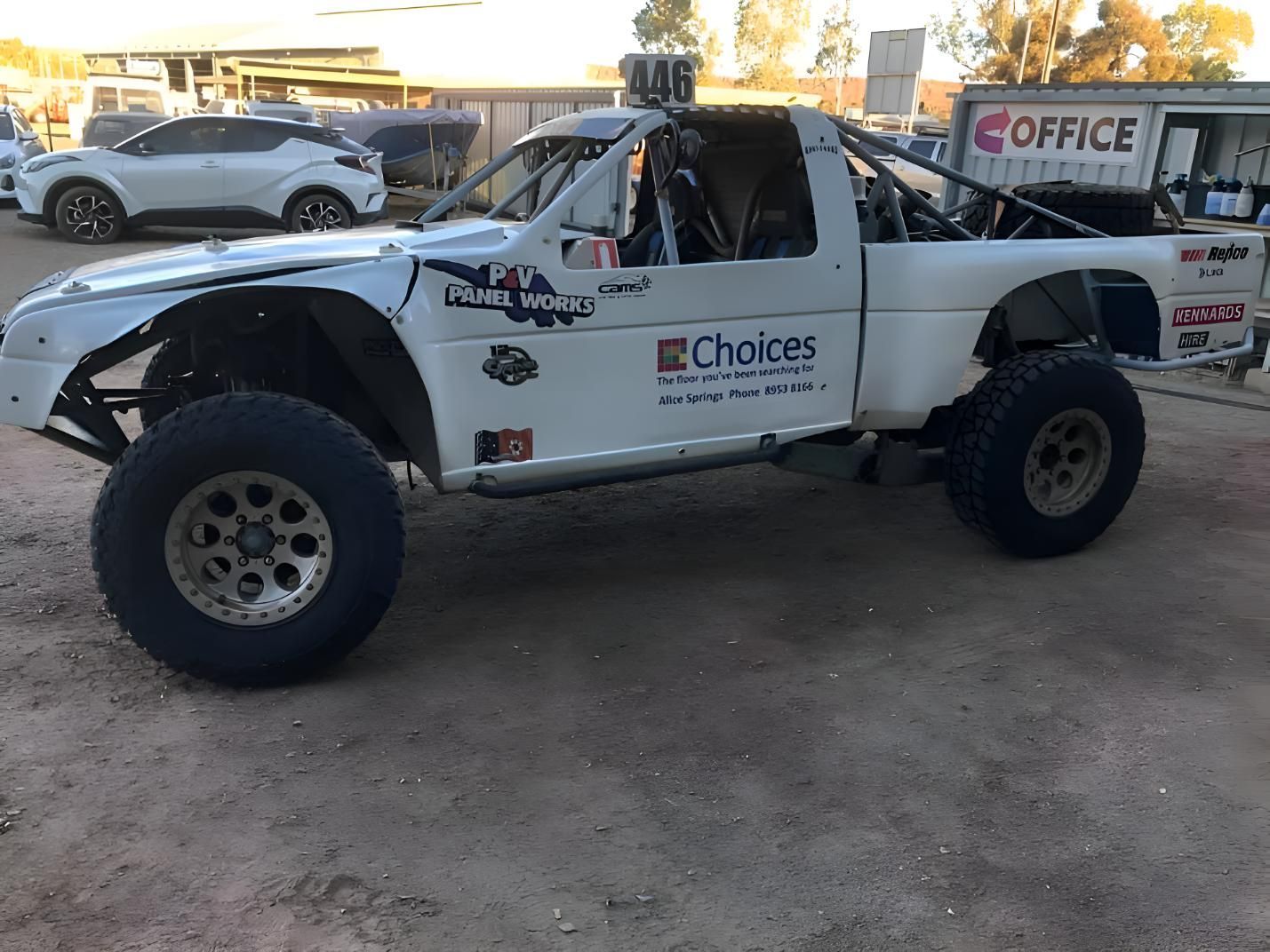 A White Truck With A Choices Logo On The Side Is Parked In A Dirt Lot — P & V Panel Works In Alice Springs, NT