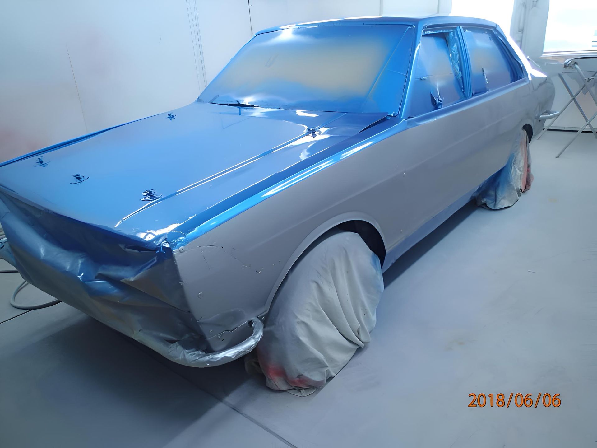 A Blue Car Is Sitting In A Paint Booth — P & V Panel Works In Alice Springs, NT