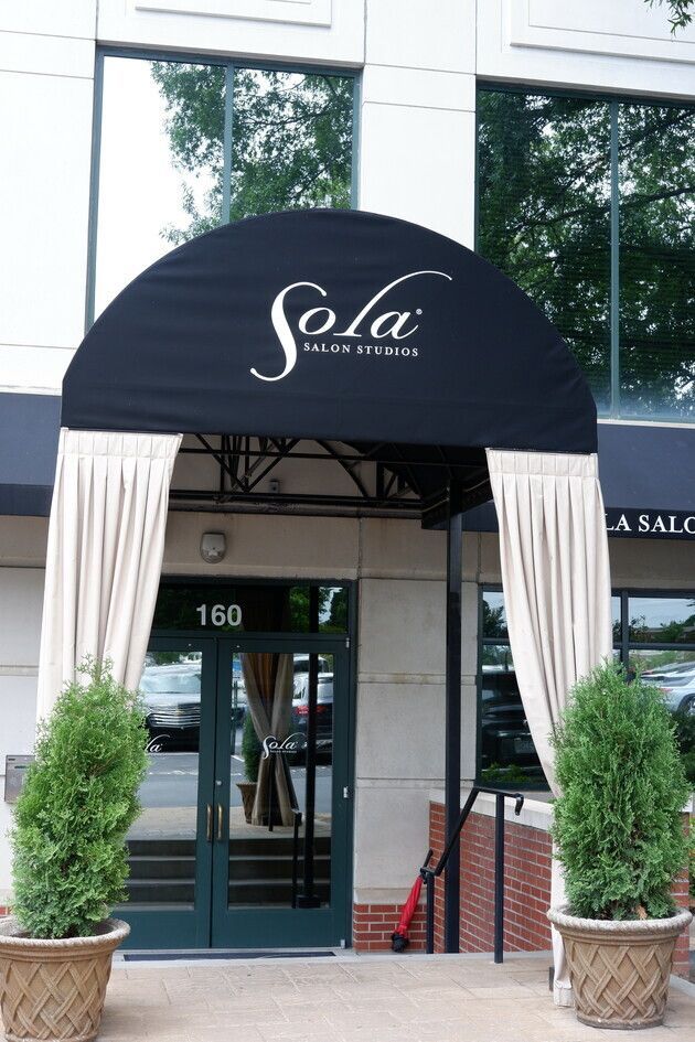 A building with a black awning that says sola on it