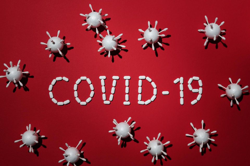 Photo of COVID-19 spelled out with medication and virus graphics