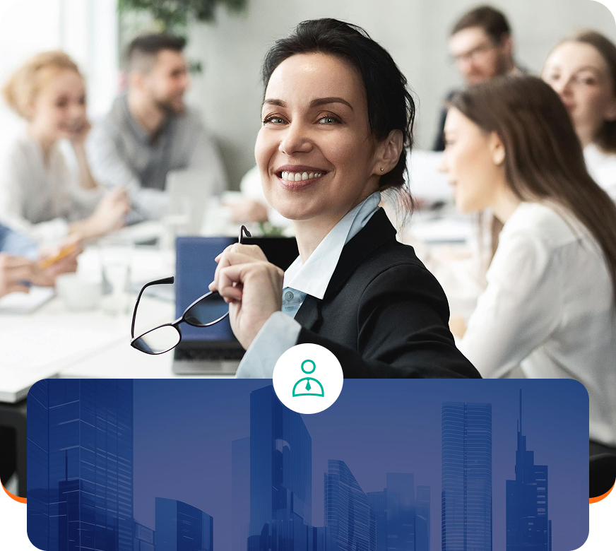 Smiling business professional holding glasses in a meeting room, with blurred colleagues in the background