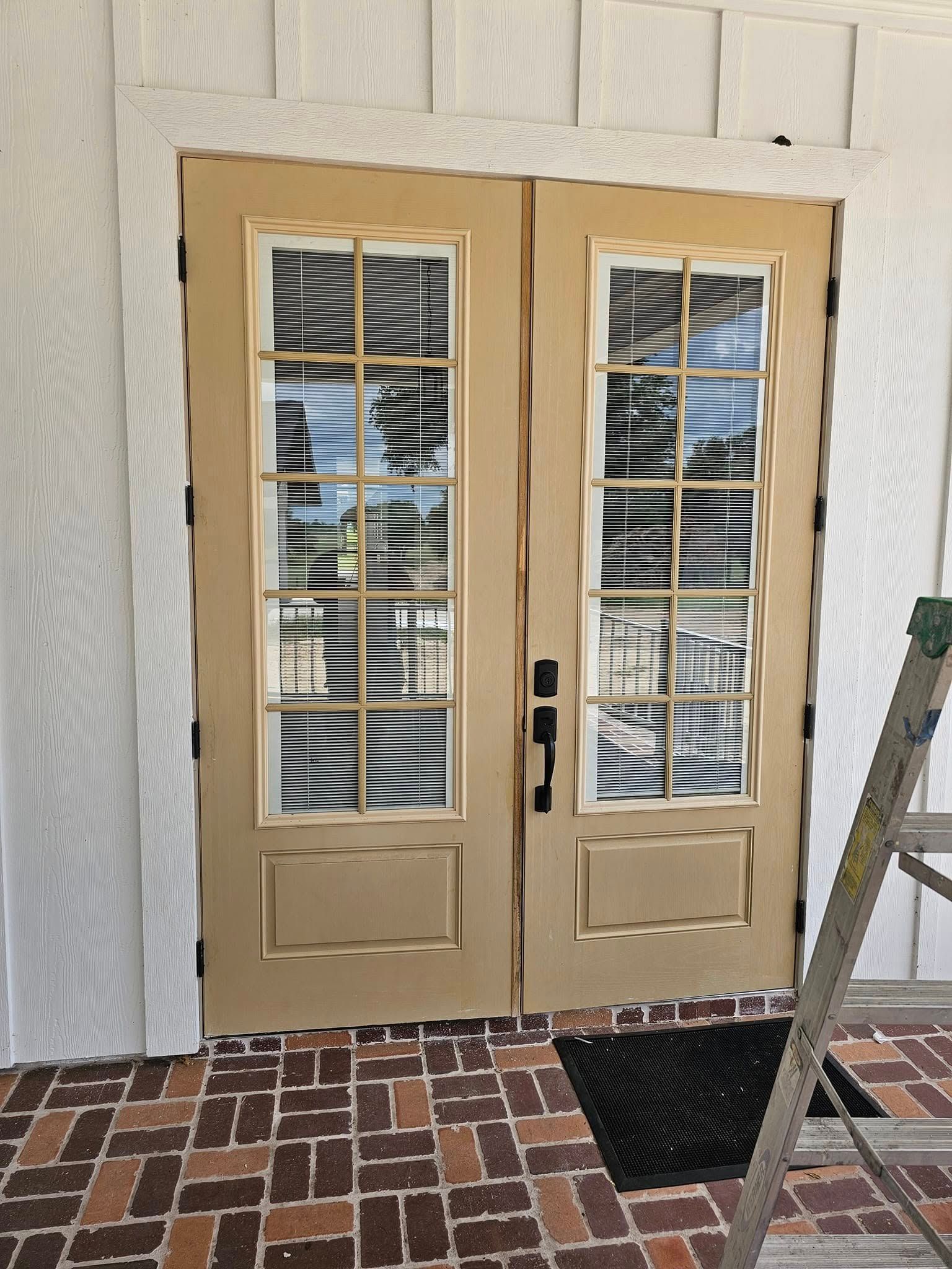 Two beige French doors with glass panes
