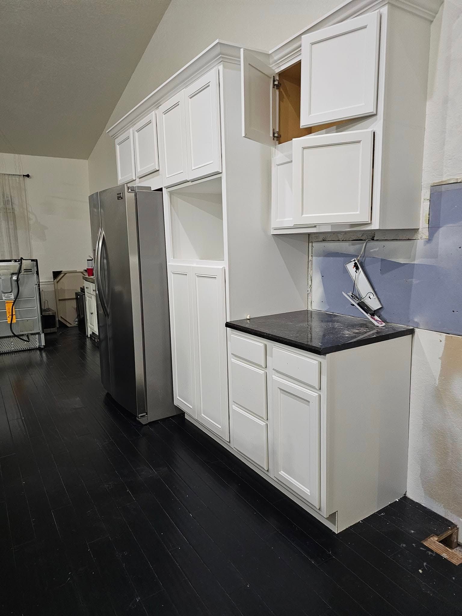 White kitchen cabinets with a stainless steel refrigerator