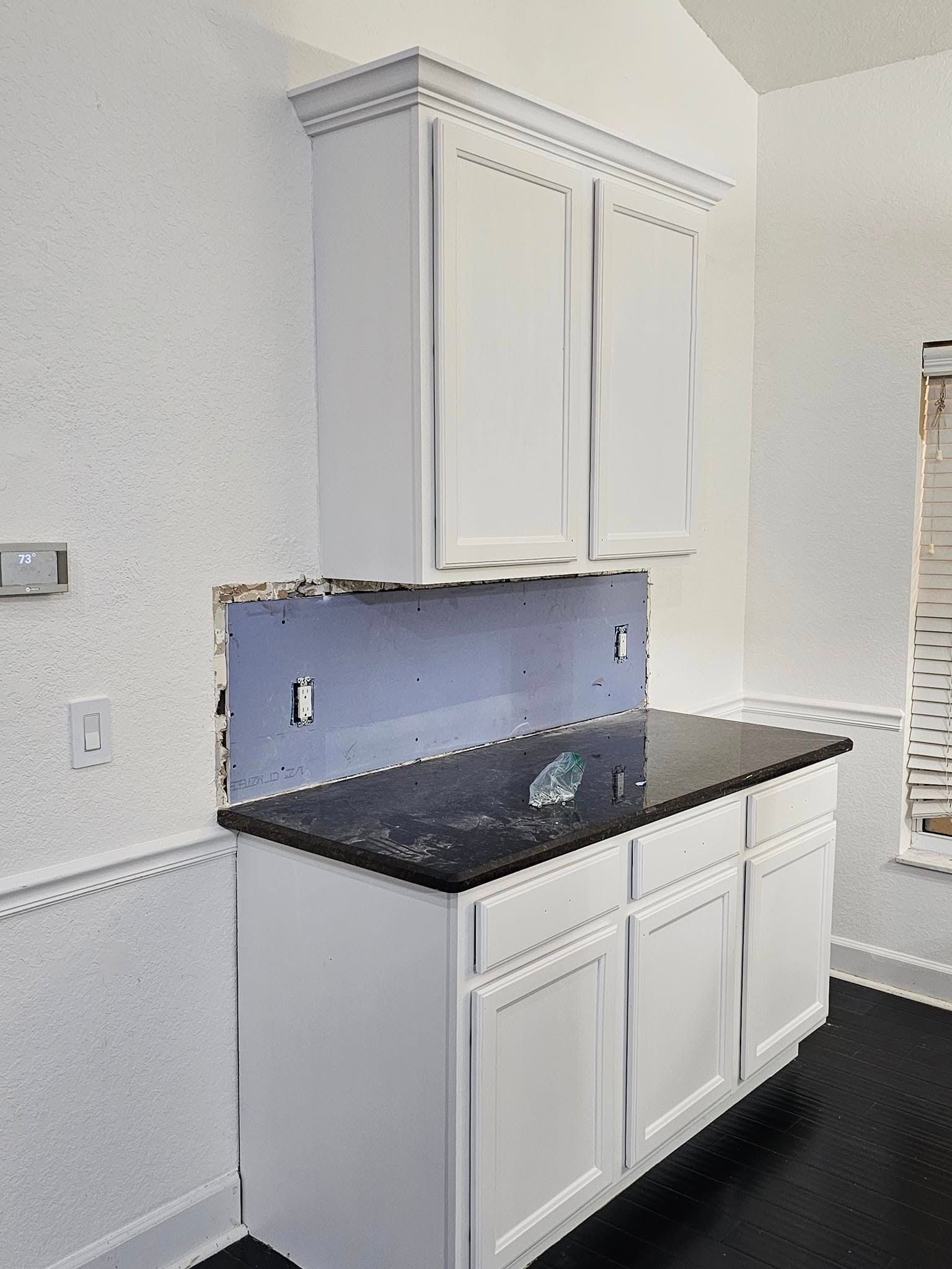 White kitchen cabinets with black countertop