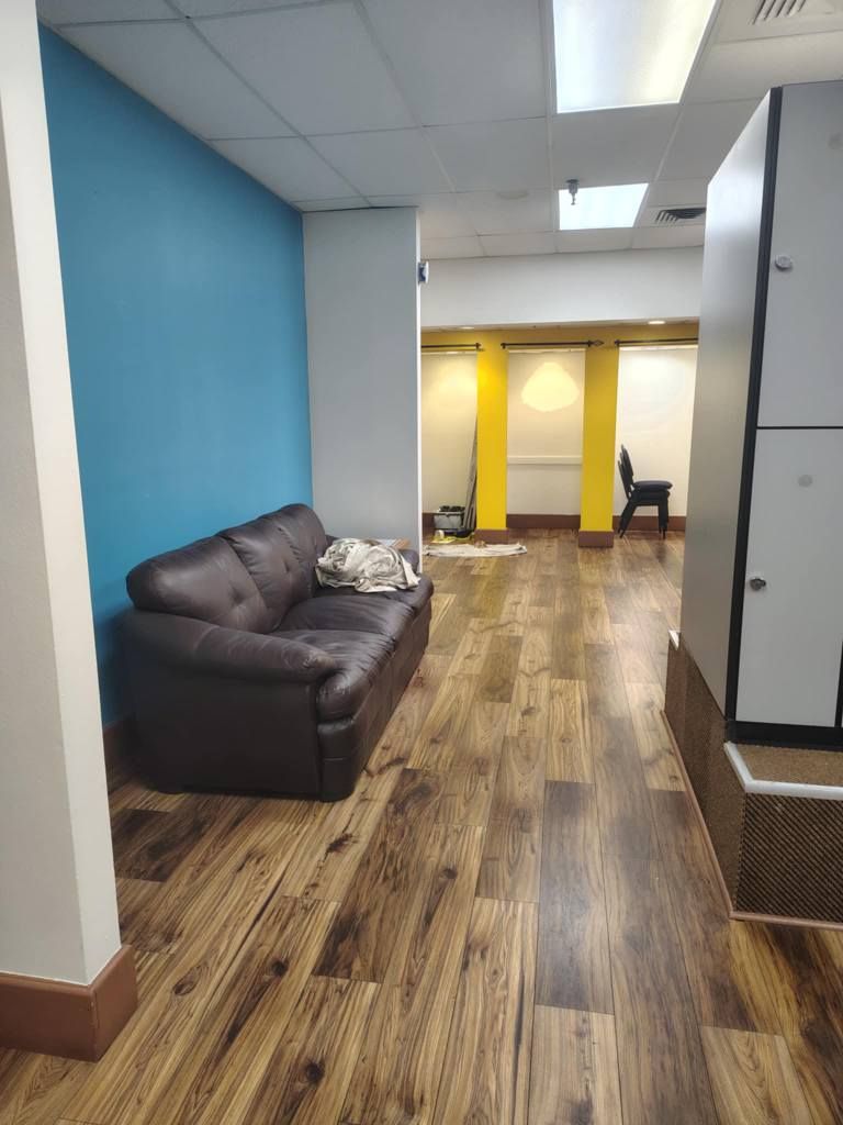 A waiting area with a brown couch against a blue wall