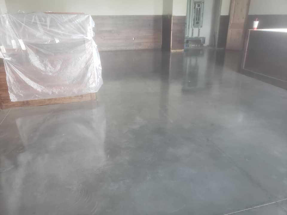 Dark gray polished concrete floor with reflections