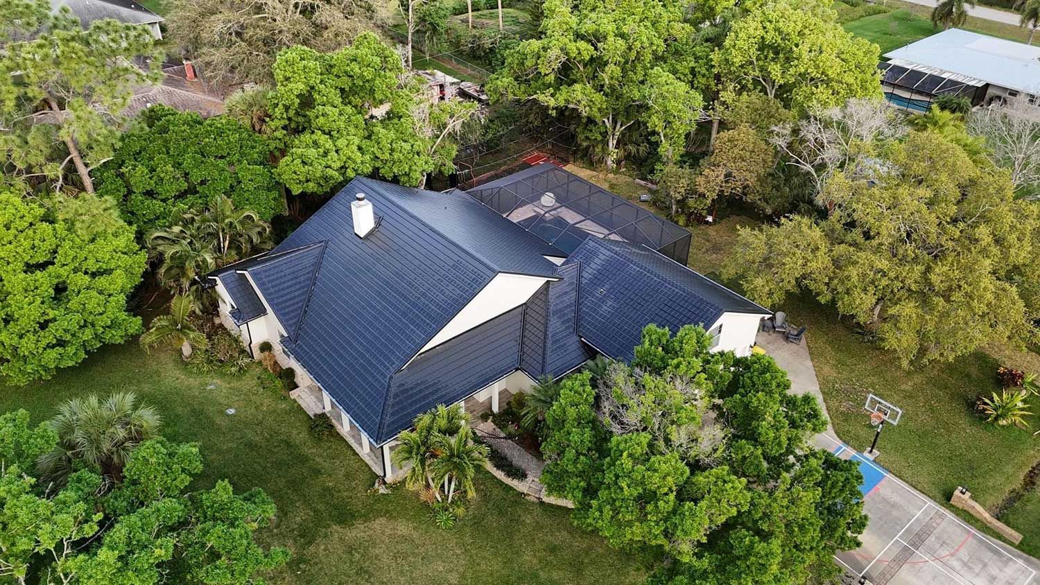 Aerial view of a house with a dark blue metal roof
