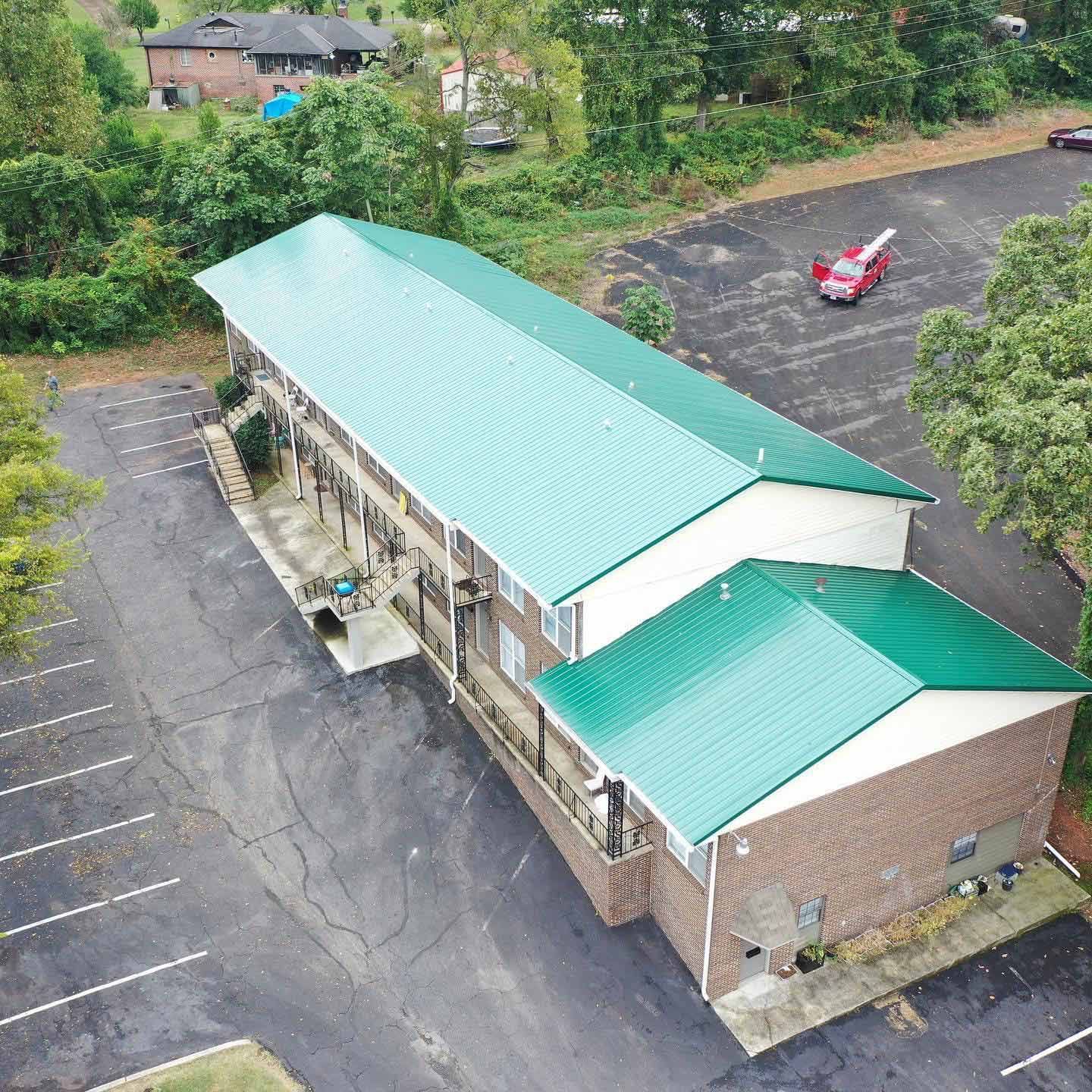 Aerial view of a building with a green metal roof