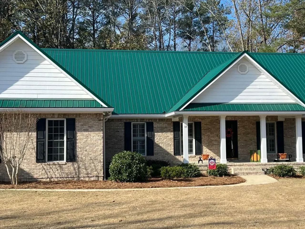 A wide house with a green metal roof A wide house with a green metal roof