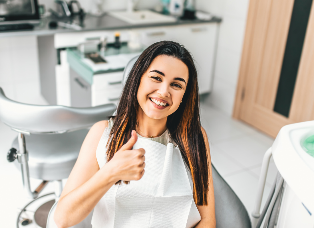 woman with thumbs up at dentist | gum disease therapy | Periodontist in Oelwein IA