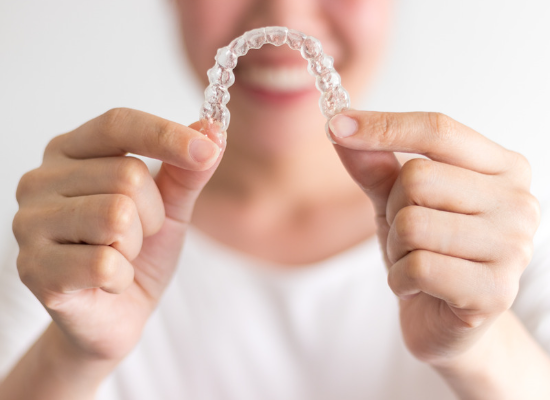 Woman holding clear aligners | Oelwein, IA Invisalign 