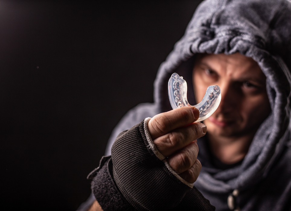man holding mouth guard | sports and night mouthguards in Oelwein IA