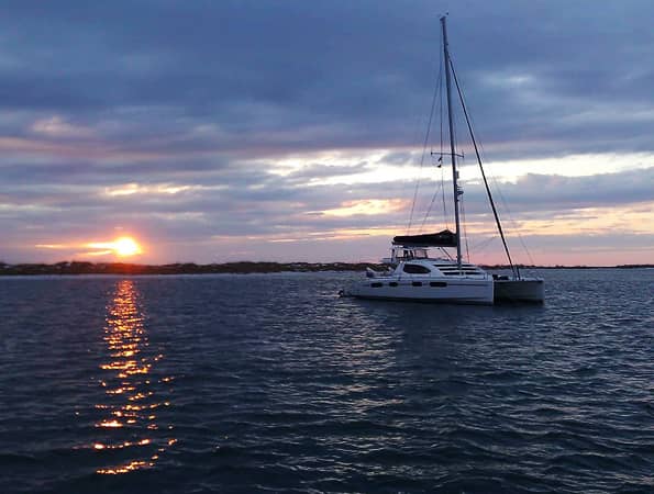 A sail boat on the water at sunset