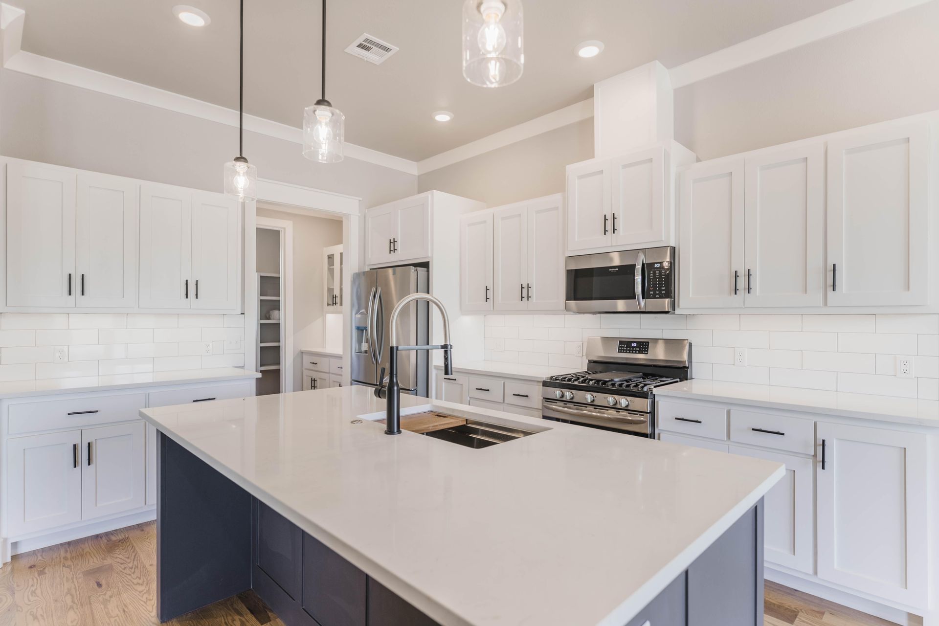 Woman in straw hat smiles, holding wine glass near a lake.