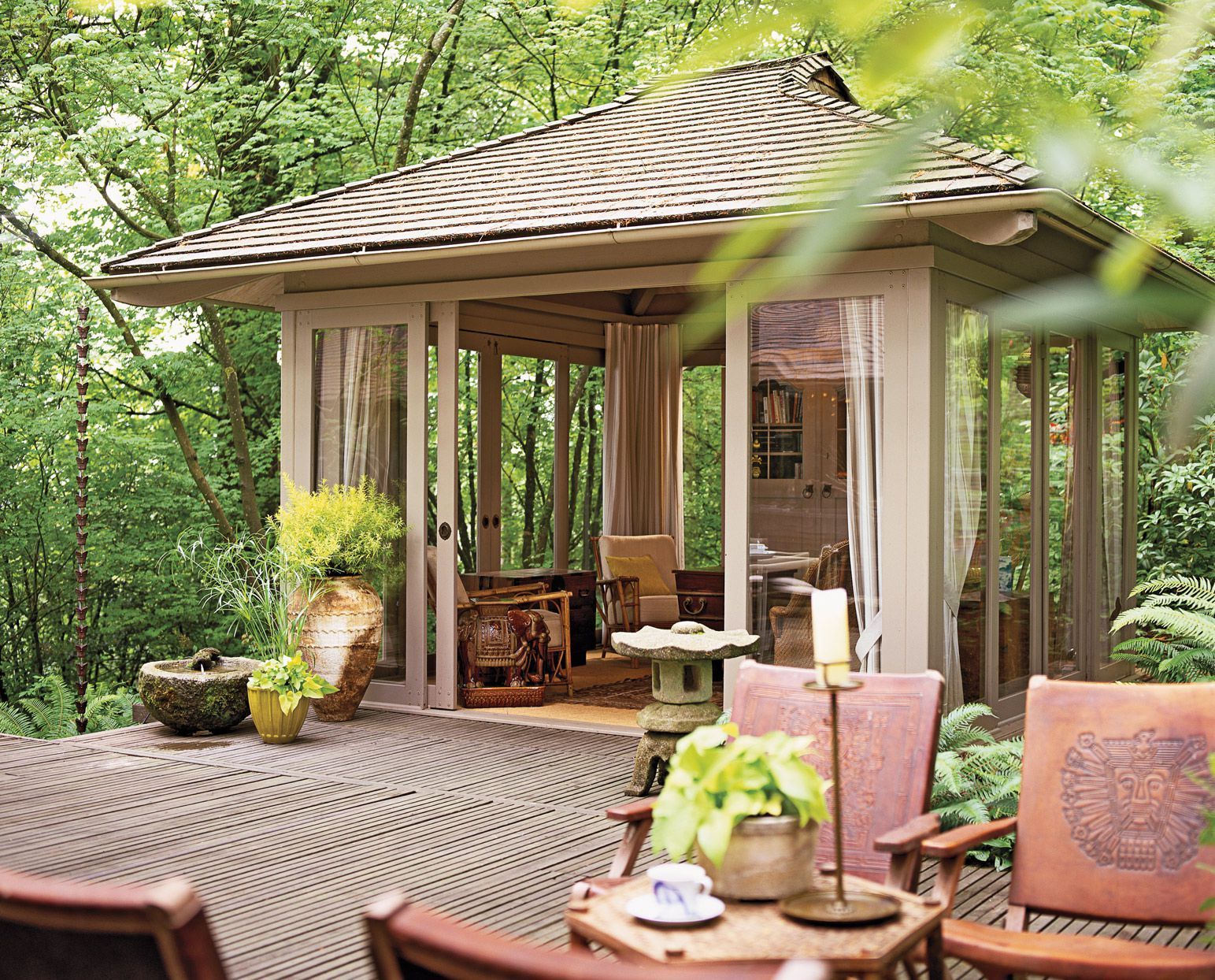 A gazebo with a table and chairs in front of it